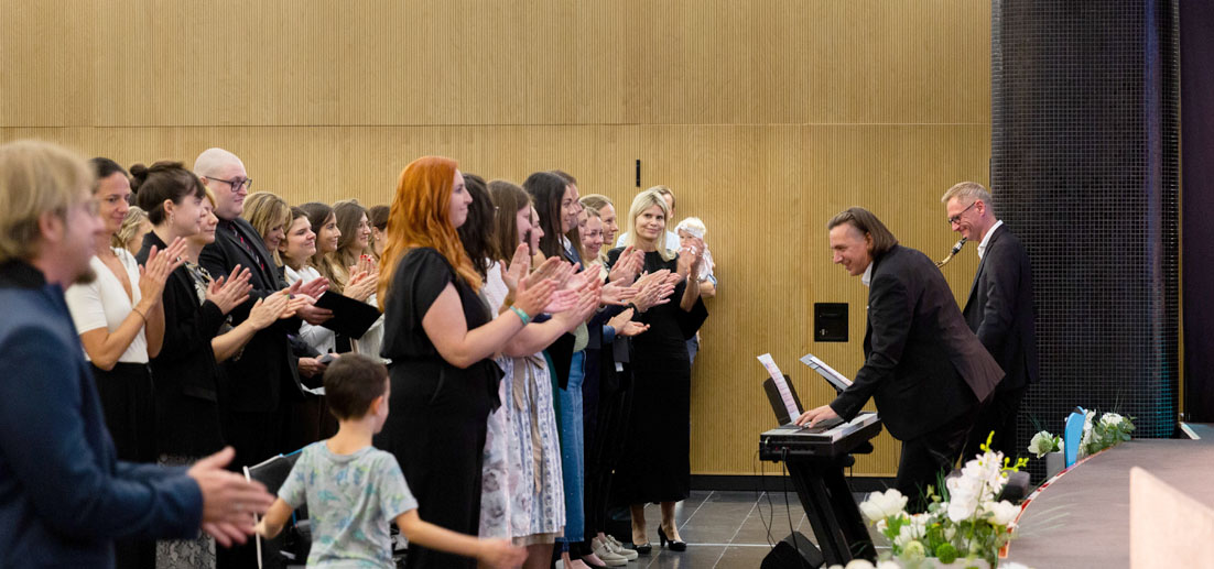 Das Bild zeigt die applaudierenden Bachelor of Arts nach dem Erhalt ihrer Diplome, begleitet vom Song „Happy“, gespielt von mairegen.at