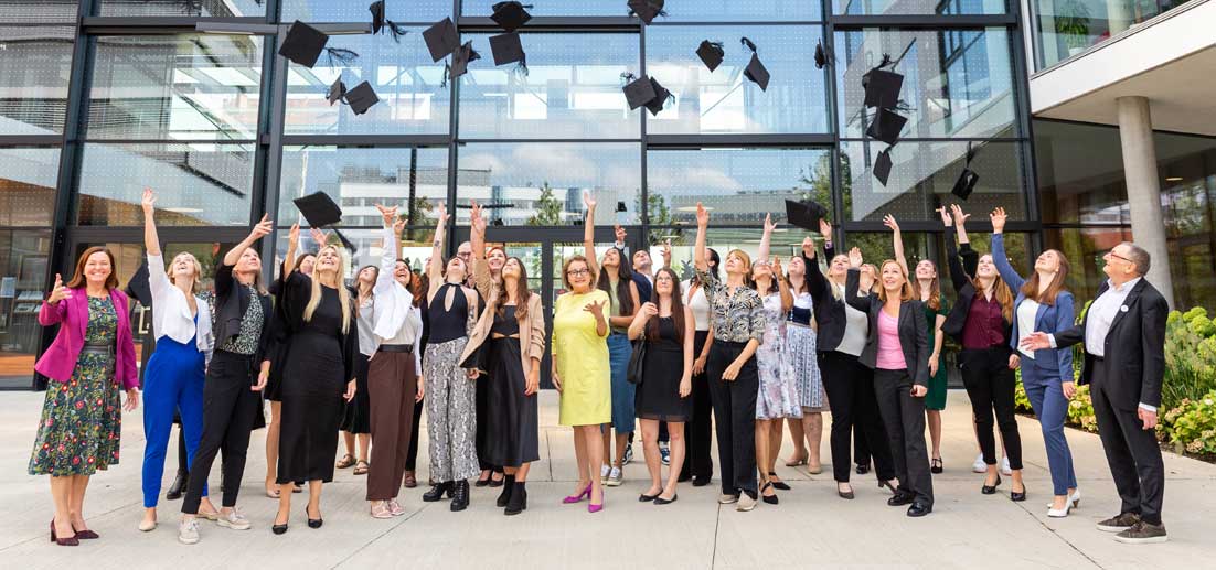 Das Bild zeigt Absolventinnen und Absolventen, Lehrende, Ehrengäste und den Rektor vor dem Campus St. Pölten.