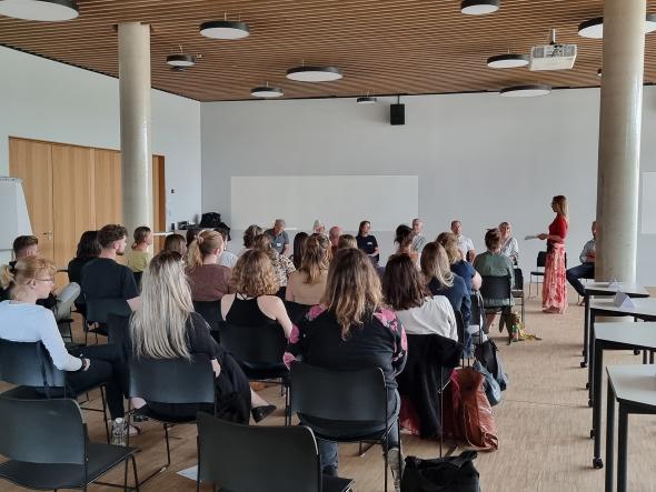 Das Bild zeigt eine Gruppe Studierender im Future Lab am Campus St. Pölten. Eine Dozentin spricht zu den Studierenden.