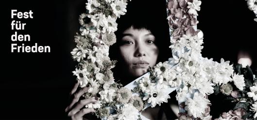Einladungsbild zum Fest des Friedens: Eine Frau hält ein aus Blumen gestaltetes Peace-Zeichen in den Händen (c) pexels.com