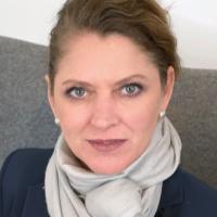 Portrait einer Frau mit zusammengebundenen dunklen Haaren.