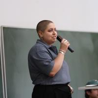 Anahita Neghabat steht und hält ein Mikrofon in der Hand.