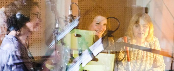 Drei Menschen singen im Studio